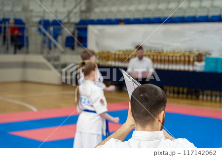 The karate referee shows marks during martial art competition. The karate referee shows marks during martial art competition. 117142062