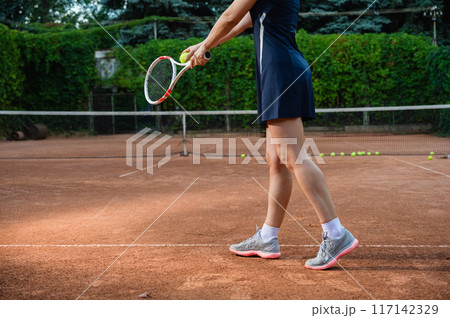 Unrecognizable female tennis player serving. Unrecognizable female tennis player serving. 117142329