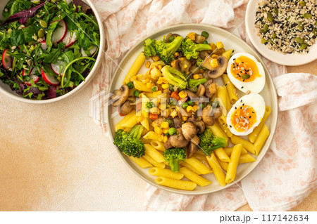 Pasta with fried mushrooms and broccoli, green peas and corn, fresh mix salad 117142634