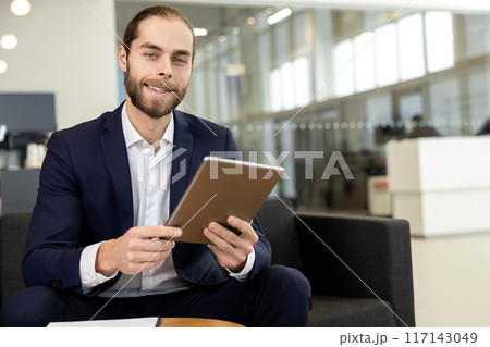 Businessman working on digital tablet at the office of car showroom 117143049