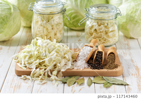 Pickling cabbage at home on table. Prepare homemade sauerkraut or fermented cabbage. Pickling cabbage at home on table. Prepare homemade sauerkraut or fermented cabbage. 117143460