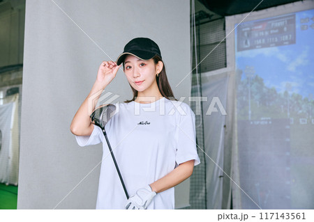 室内ゴルフ練習場で練習をする女性 117143561