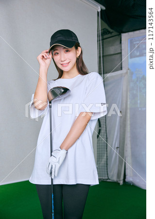 室内ゴルフ練習場で練習をする女性 117143564