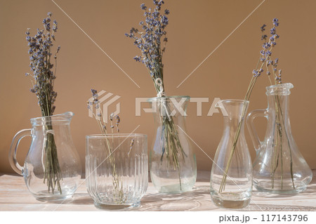 Dried lavender flowers in glass vase on neutral beige background. Minimal still life eco concept. Minimalistic interior decor with lavender flowers 117143796