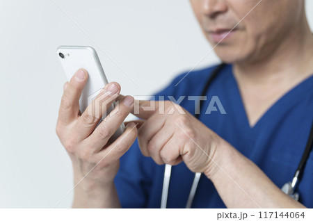 スマートフォンを操作する50代医療従事者 117144064