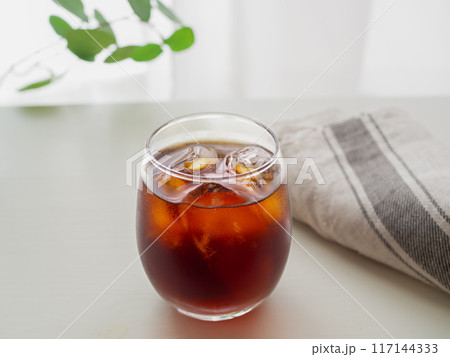 白いテーブルに置かれたグラスに入ったアイスコーヒー 白いテーブルに置かれたグラスに入ったアイスコーヒー 117144333