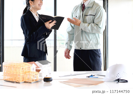 建設模型の前で話し合いをする男女の会社員 建設模型の前で話し合いをする男女の会社員 117144750