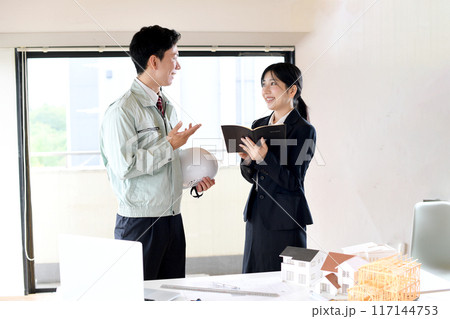建設模型の前で話し合いをする男女の会社員 建設模型の前で話し合いをする男女の会社員 117144753