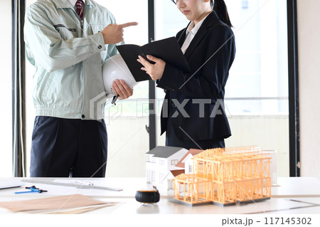 建設模型の前で口論をする男女の会社員 建設模型の前で口論をする男女の会社員 117145302
