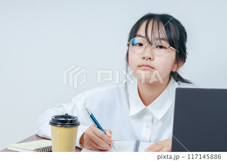 学習中の眼鏡をかけたカメラ目線の女の子 学習中の眼鏡をかけたカメラ目線の女の子 117145886