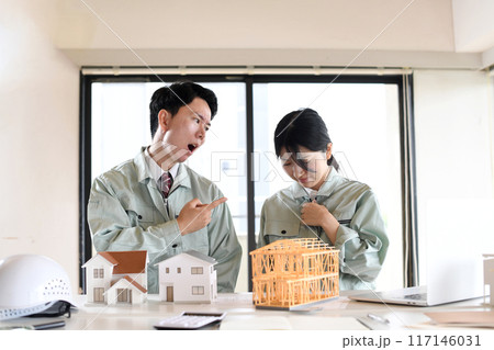 建設模型の前で口論をする男女の作業員 117146031