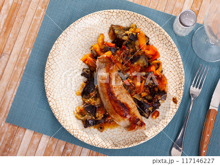 Delicious baked pork thigh with stewed vegetables on plate Delicious baked pork thigh with stewed vegetables on plate 117146227