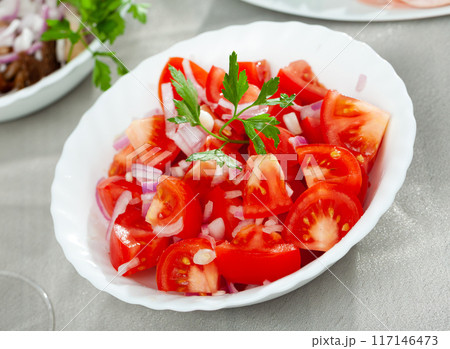 Vegetarian salad with tomatoes, onion, greens and olive oil Vegetarian salad with tomatoes, onion, greens and olive oil 117146473