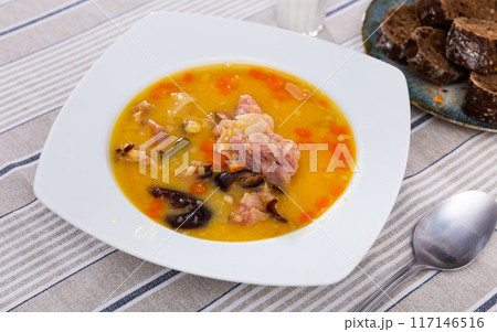 Hot pea soup with smoked meats and vegetables 117146516