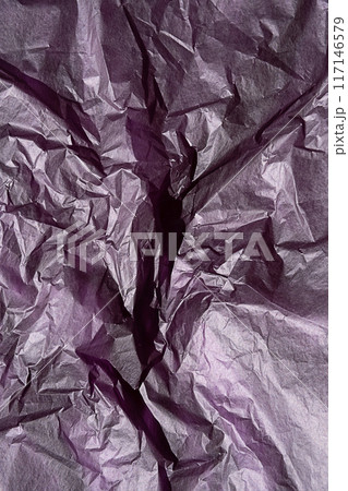 Crumpled purple paper texture with detailed wrinkles and creases, close up view. Crumpled purple paper texture with detailed wrinkles and creases, close up view. 117146579