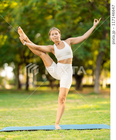 Funny moment of yogini losing balance during workout in park Funny moment of yogini losing balance during workout in park 117146647