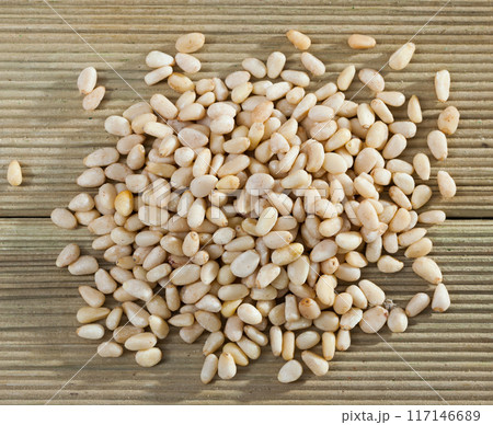 Pile of delicious pine nuts on a wooden surface Pile of delicious pine nuts on a wooden surface 117146689