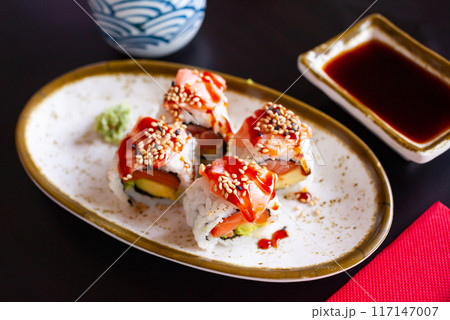 Uramaki with salmon, avocado, unagi sauce and sesame 117147007