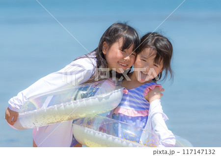 夏休みに海で海水浴をして遊ぶ女の子 117147132