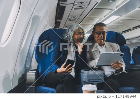 Happy elderly senior couple of travelers with suitcase in airport Happy elderly senior couple of travelers with suitcase in airport 117149944