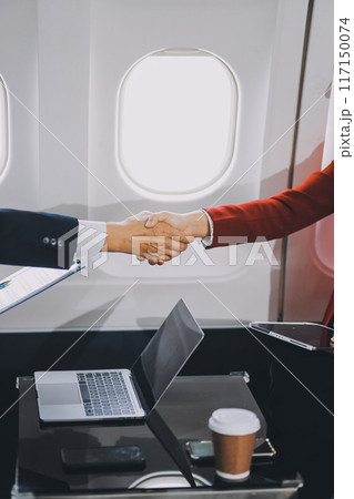 business people at meeting in private plane, Asian businessman in suit is talking to woman in jet and pointing at blank laptop screen, colleagues are discussing deal and flying in plane business people at meeting in private plane, Asian businessman in suit is talking to woman in jet and pointing at blank laptop screen, colleagues are discussing deal and flying in plane 117150074