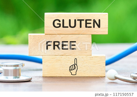 top view Phrase Gluten free written on wooden blocks against a background of blurred green plants 117150557