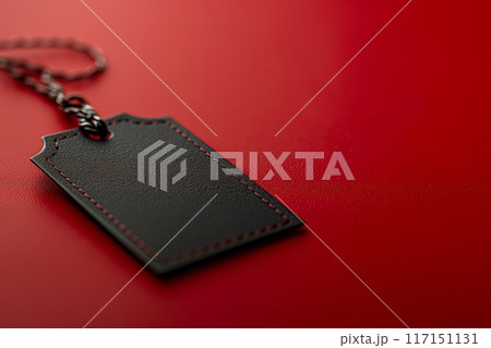 Stylish black leather tag with red stitching on a textured background, showcasing premium quality 117151131