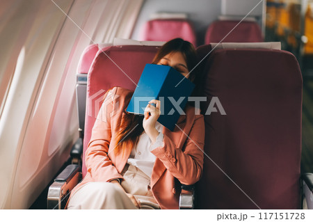 Tired asian woman with headache feeling sick while sitting in the airplane , Passengers near the window. Tired asian woman with headache feeling sick while sitting in the airplane , Passengers near the window. 117151728