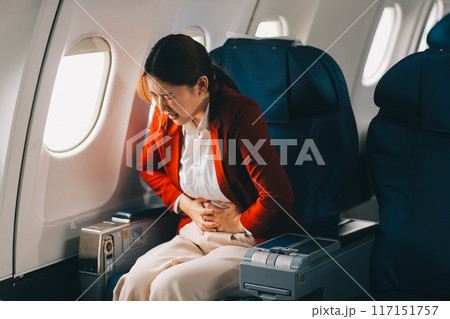 Photo of a frustrated woman sitting on an airplane with her head in her hands. Asian woman sitting in a seat in airplane Photo of a frustrated woman sitting on an airplane with her head in her hands. Asian woman sitting in a seat in airplane 117151757