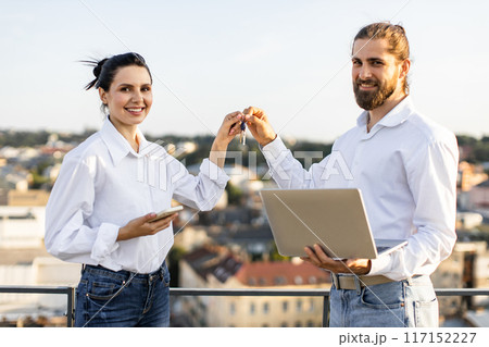 Happy couple celebrating new home purchase on rooftop 117152227