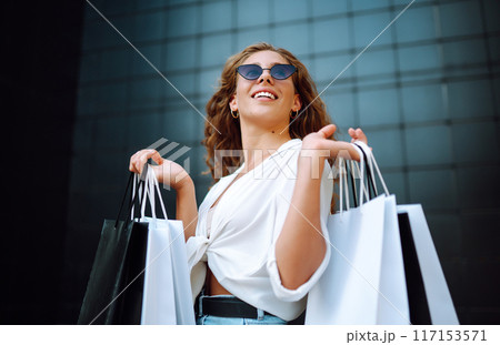 Woman in shopping. Woman with shopping bags walking around city after shopping. Lifestyle concept. Woman in shopping. Woman with shopping bags walking around city after shopping. Lifestyle concept. 117153571