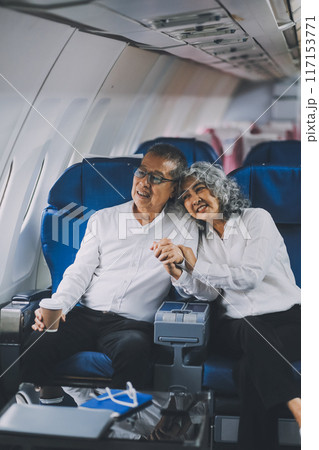 Happy elderly senior couple of travelers with suitcase in airport 117153771