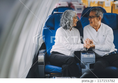 .A mature couple enjoys a plane ride sitting near the window. They looked out into the sky. Immerse yourself in the scenery and excitement of the journey. To create precious memories together .A mature couple enjoys a plane ride sitting near the window. They looked out into the sky. Immerse yourself in the scenery and excitement of the journey. To create precious memories together 117153782
