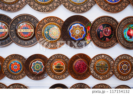 traditional Uzbek wooden handmade gift plates with wood carvings hand-painted in market of Uzbekistan 117154132