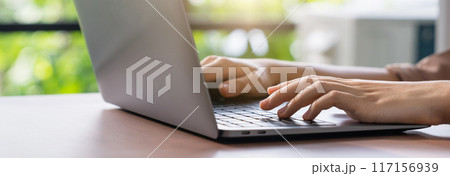 Hand using computer laptop and touching mouse on the table. 117156939