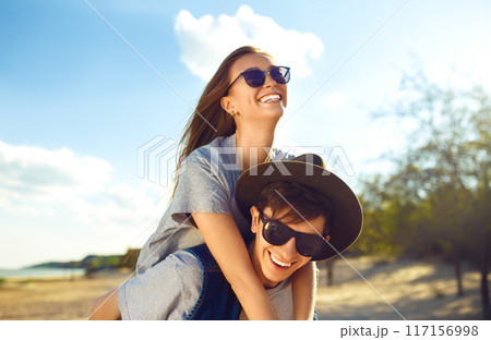Group of friends enjoying time on beach. Laugh and smile. Friendly atmosphere. Guys enjoy photos. 117156998