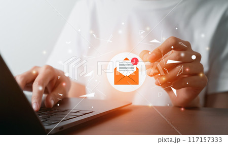 Hand using laptop with holding pen and shows a digital screen of new email notifications. 117157333