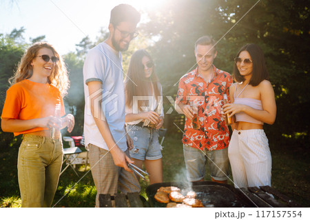 ?ompany of people having bbq party on in summer park. Lifestyle, holidays, weekend, leisure concept. 117157554