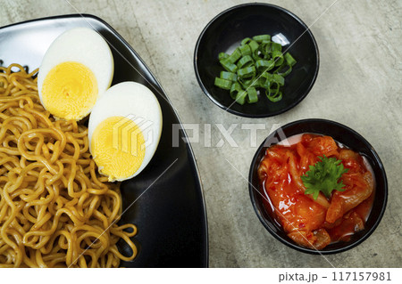 A plate of instant noodles with tomatoes and egg on top 117157981