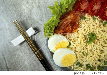 A bowl of instant noodles with eggs and tomatoes 117157987