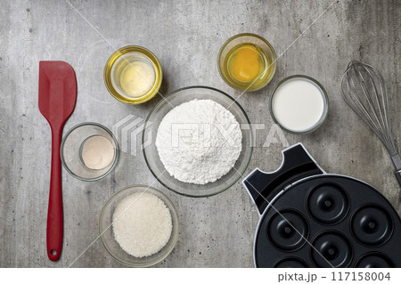 A kitchen counter with a variety of ingredients and utensils for making donuts A kitchen counter with a variety of ingredients and utensils for making donuts 117158004