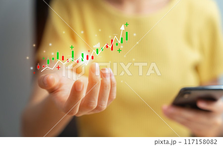 Woman trader is showing a growing and stock market graph and investment and currency exchange, Buy and sell on smartphone, Planning and strategy concept 117158082