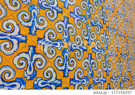 Vintage yellow and blue tiles. Beautiful view to old historic portuguese tiles on building facade Vintage yellow and blue tiles. Beautiful view to old historic portuguese tiles on building facade 117158297