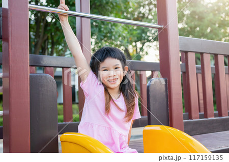 Cute asian girl playing on the slide in the playground 117159135