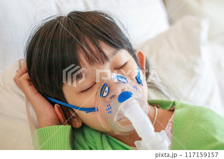 Sick little asian girl inhalation with nebulizer for respiratory treatment 117159157
