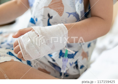 Close up child hand with saline IV solution in hospital Close up child hand with saline IV solution in hospital 117159425