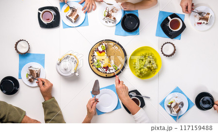 people eating dessert and drinking tea, top view people eating dessert and drinking tea, top view 117159488