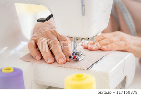Old woman hands sewing on machine Old woman hands sewing on machine 117159879