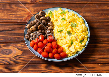 Homemade scrambled eggs with mushrooms and cherry tomatoes Homemade scrambled eggs with mushrooms and cherry tomatoes 117160298