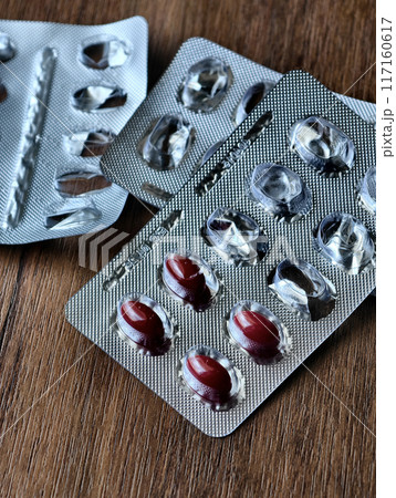 A nearly empty blister packs of pills on a wooden table A nearly empty blister packs of pills on a wooden table 117160617